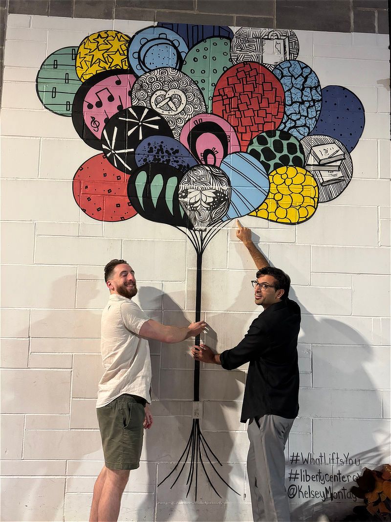 Matt and Turab posing in front of a balloon mural