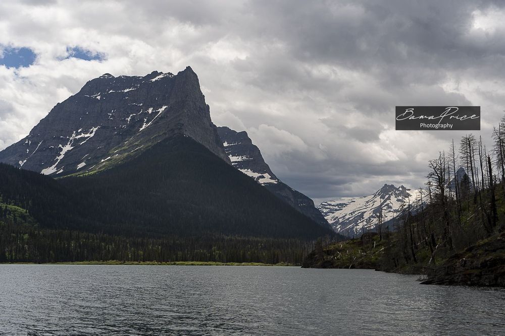 Little Chief Mountain rising beyond St. Mary Lake beneath dramatic clouds in Glacier National Park, Montana.