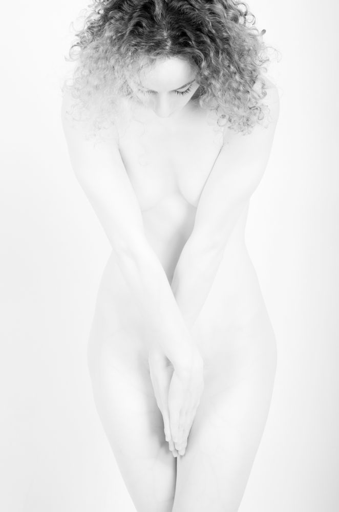 An implied photograph of a woman looking down with her hands criss crossed