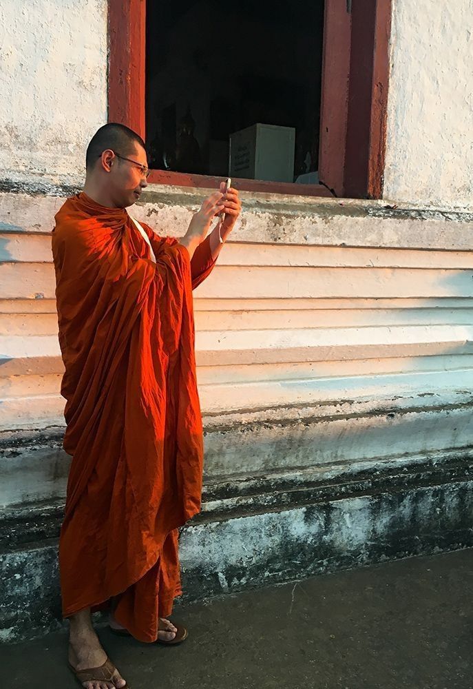 A Buddhist monk in Luang Prabang, Laos, during sunset at Mount Phou Si