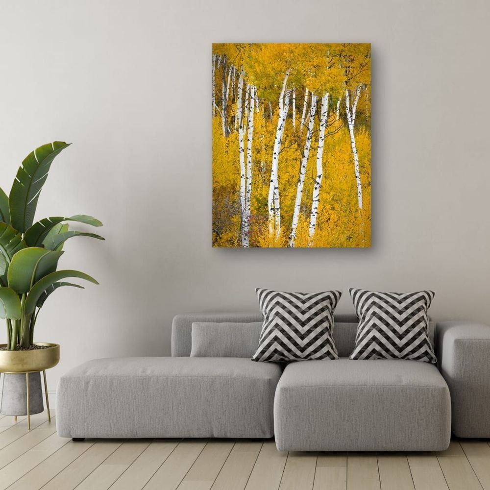 Large metal print of golden aspen trees displayed above a gray sectional in a contemporary living room.