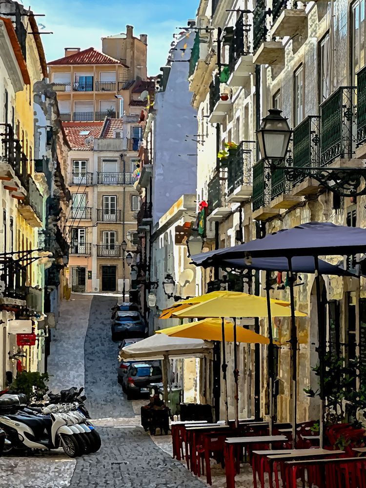 Cafe street scene on shaded Lisbon cobblestone. 
