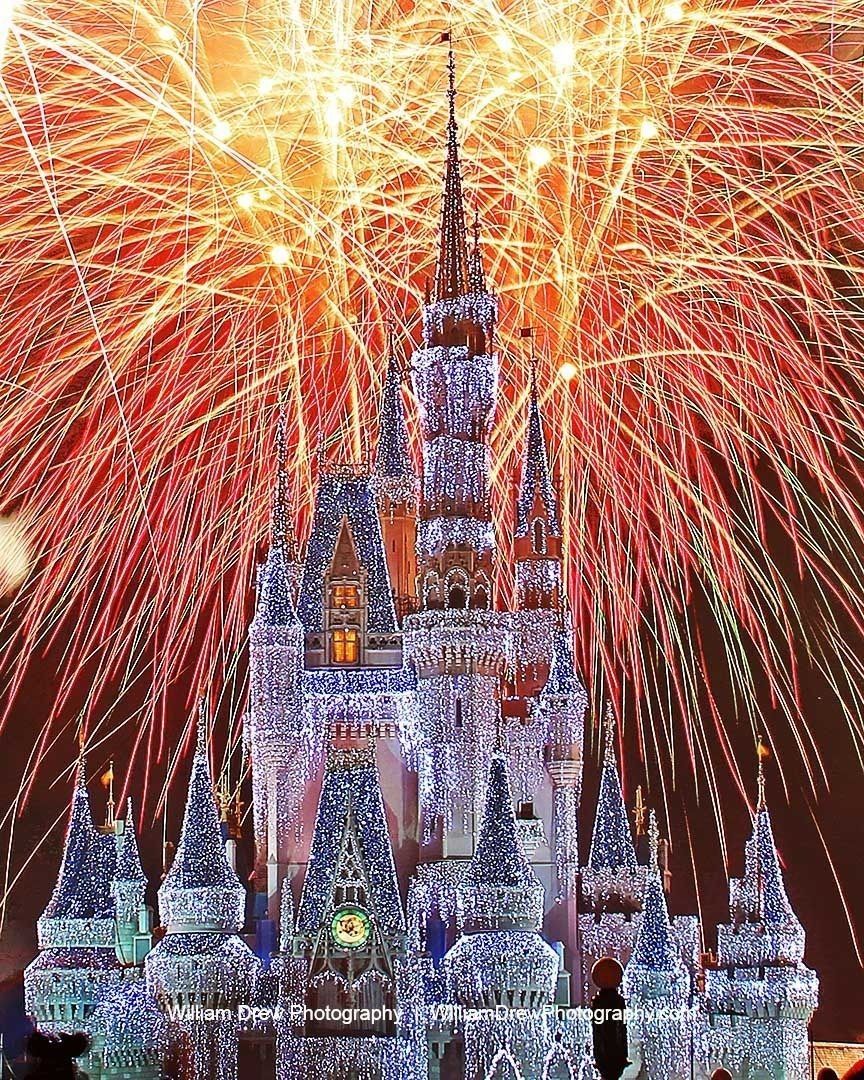 White Christmas Wishes - Cinderella Castle lit in white christmas lights while the fireworks from Christmas Wishes lights up the sky above it.
