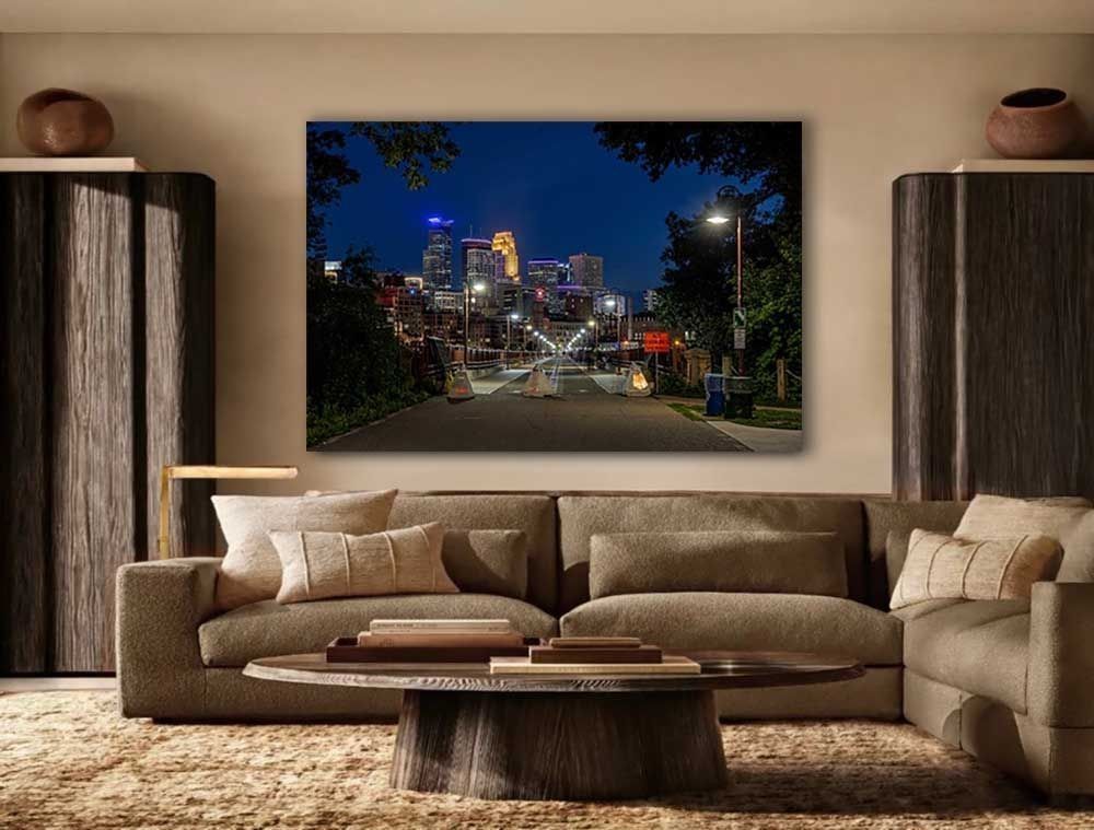 The Stone Arch Bridge staged for July 4th with downtown Minneapolis glowing beyond - fine art print on a living room wall above a couch