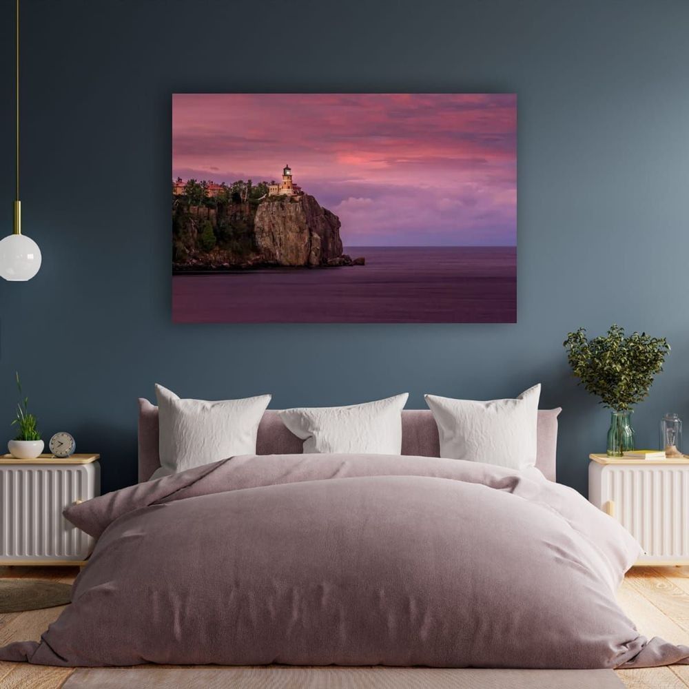 Split Rock Lighthouse sits atop a 130' cliff on Lake Superior in a fine art print above a bed.