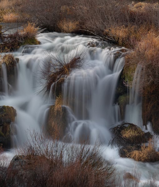 Stunning silky waterfall through autumn grasses