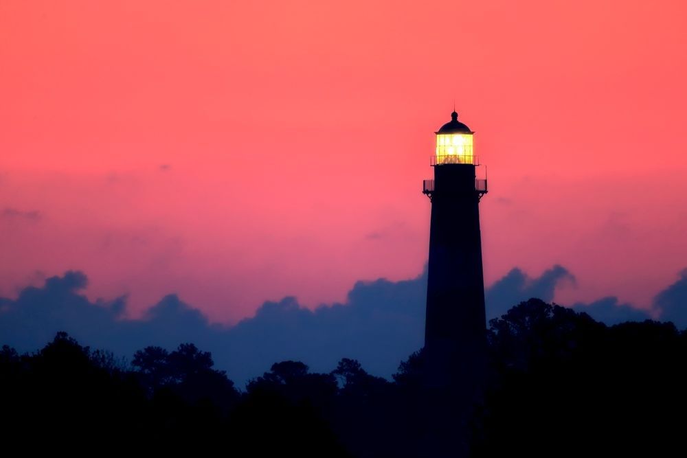 Assateague Lighthouse at sunrise with coastal marsh and Atlantic sky at Chincoteague National Wildlife Refuge Virginia photographed by Robbie George