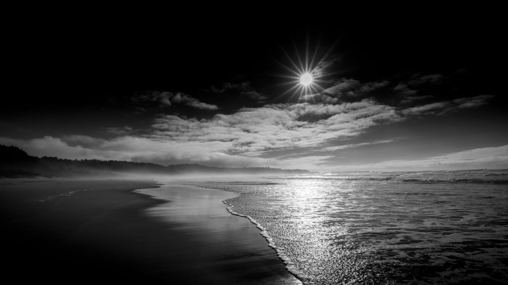Evening Light On Coos Bay — Sunburst And Shoreline In Black And White Photography Art | Harry Beugelink Photography