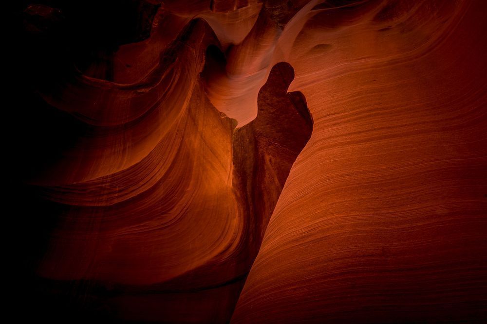 Thumbs Up. A thumb shape carved by erosion in the smooth curved Red Navajo Sandstone walls of Owl Canyon, one of the famous Slot Canyons in the Navajo lands near Page Arizona, United States. It was interesting that we stood right in front to the fea