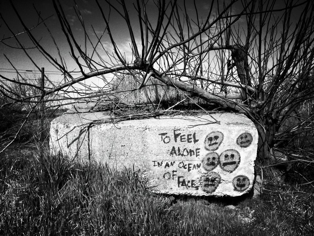 A discarded concrete construction slab has been claimed with a sad message: "To feel along in an ocean of faces."