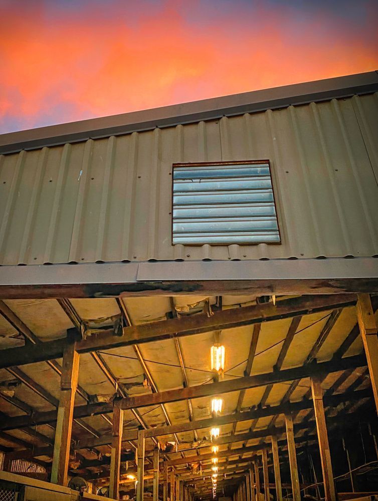 Empty horse stalls glow beneath the sunset clouds at Woodland Stallion Station, Yolo County.
