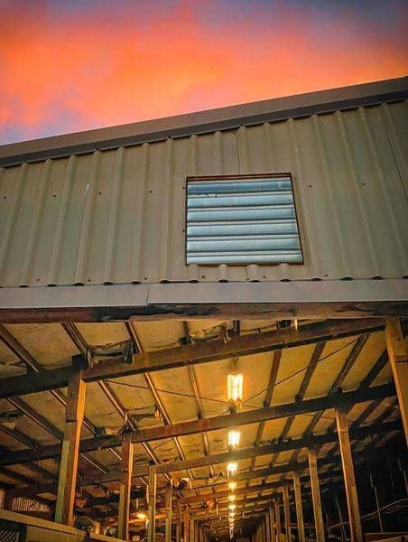 Empty horse stalls glow beneath the sunset clouds at Woodland Stallion Station, Yolo County.