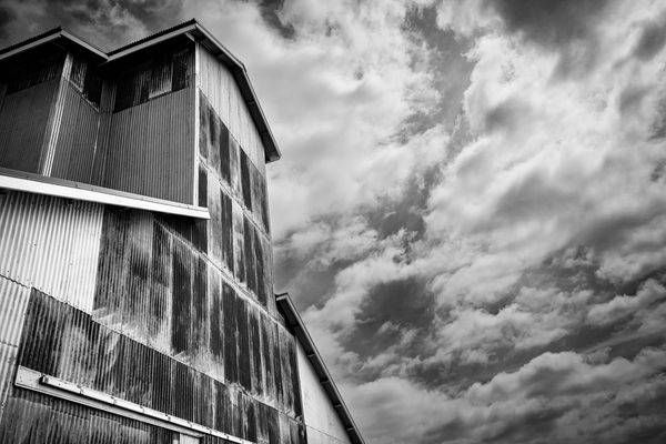 An abandoned building at the edge of farmland awaits restoration and reuse.