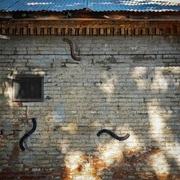Morning sunlight casts shadows upon  a brick wall that was once part of one of the original Wells Fargo buildings.