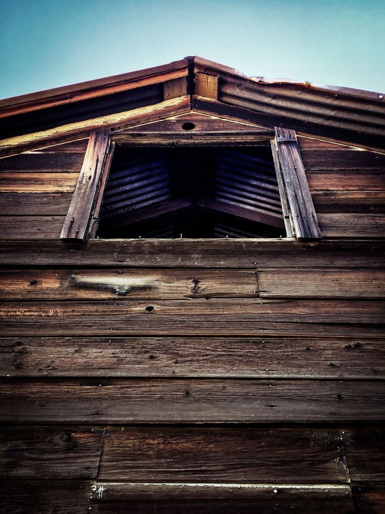 Light enters the peak of a weathered barn at Rominger Brothers Farm in Yolo County, California.