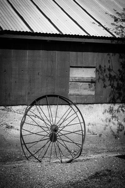 A rusting wheel rests against a barn wall at the Yolo Land and Cattle Company.