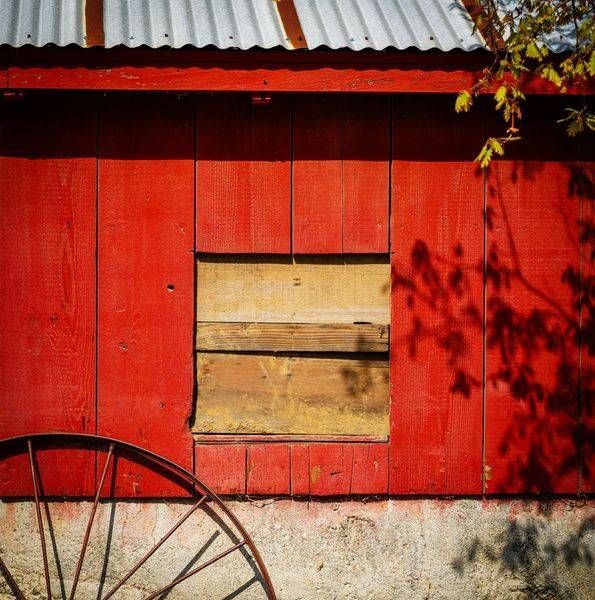 A rusting wheel rim leans against a barn wall at the Yolo Land and Cattle Ranch.
