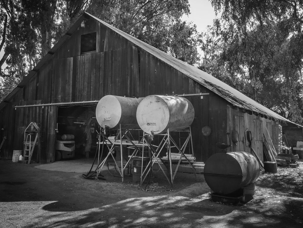 Storage tanks stand outside a weathered barn in Winters, Yolo County, California.