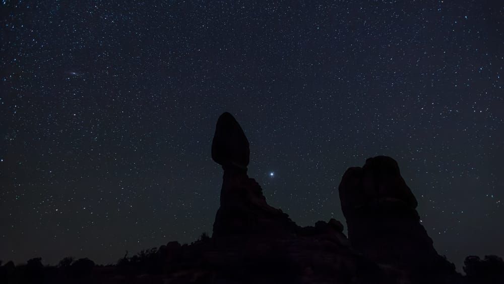 Balanced Rock at night in Arches National Park, Utah, USA. Jupiter shines bright in the sky.