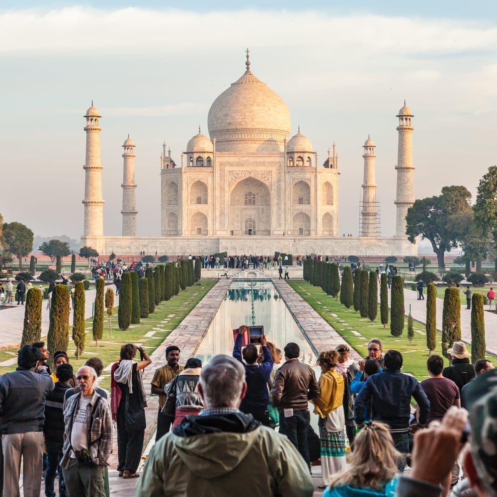 The Taj Mahal in Agra, Uttar Pradesh, India with tourists in the foreground.