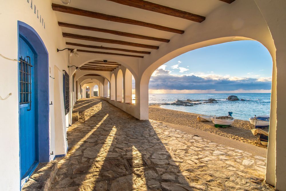 Sunrise in Calella - Coastal village scene with soft sunrise tones and calm sea