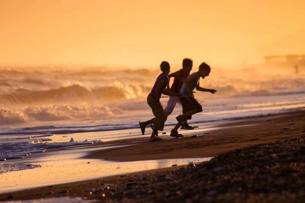 The Joy of the Sea - Children running on a Mediterranean beach in warm natural light