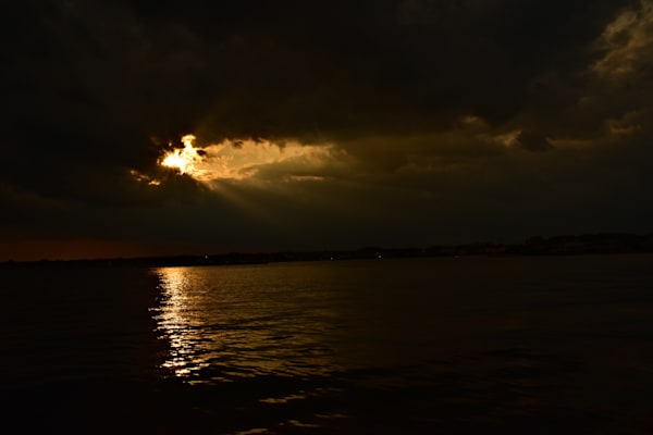 dark skies, storm-clouds, pierced by the sun, dark and light
