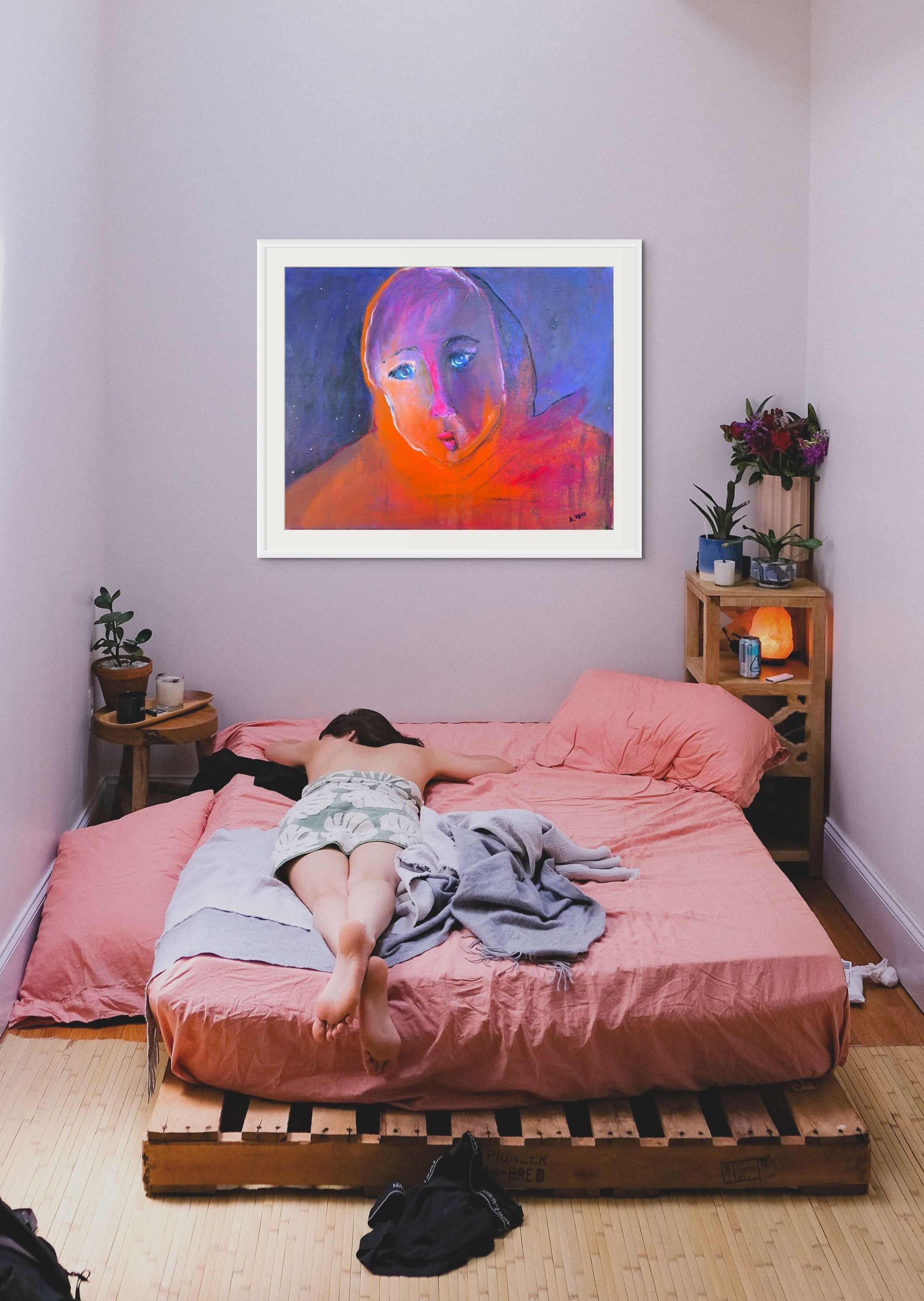 Beautiful open-edition fine art print in white wood frame above a pink bed in an intimate bedroom with lavender walls