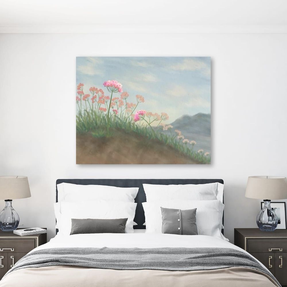 A minimalist, desert floral painting hanging on the wall of a bedroom.